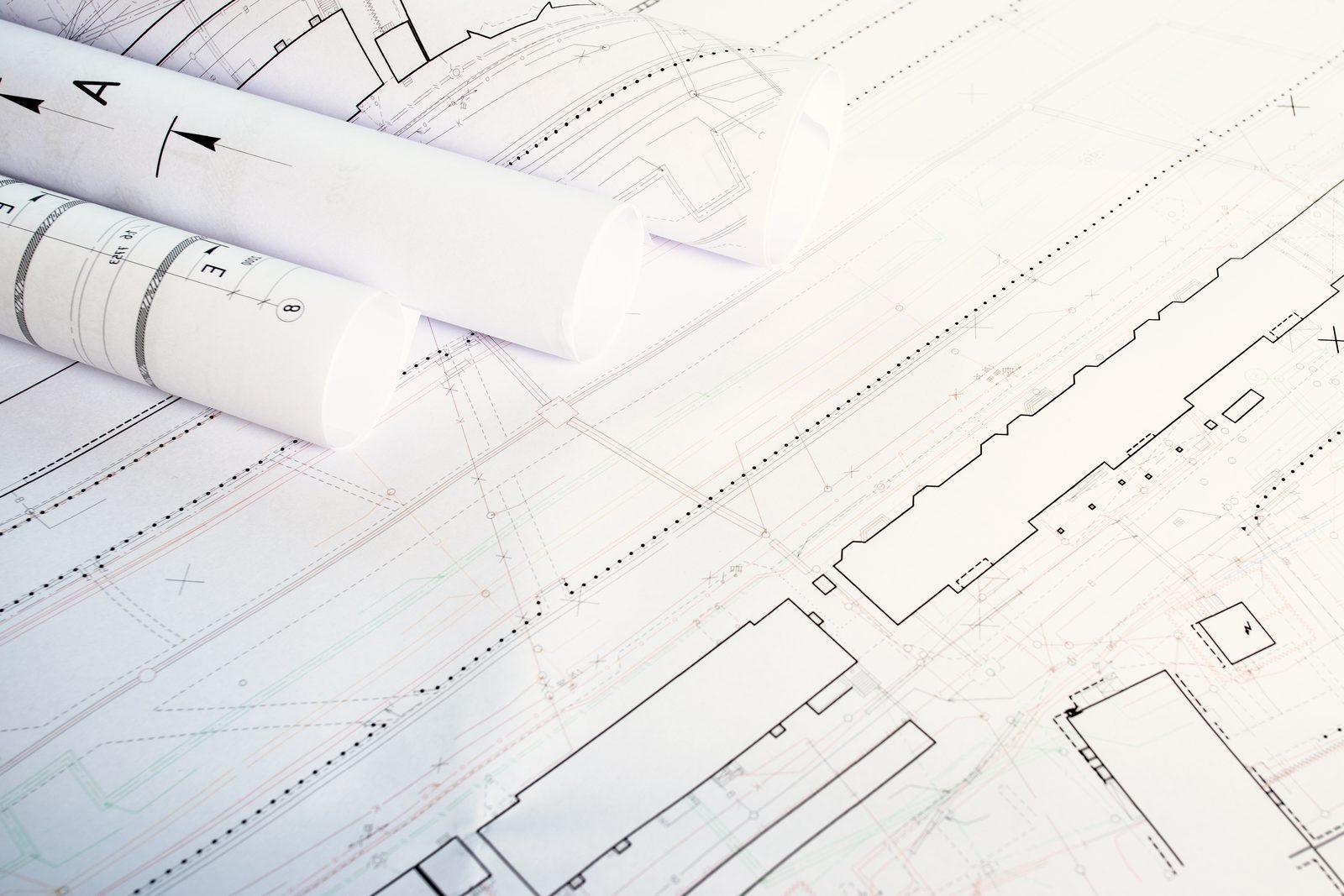 Rolled architectural drawing sheets on a printed floor plan